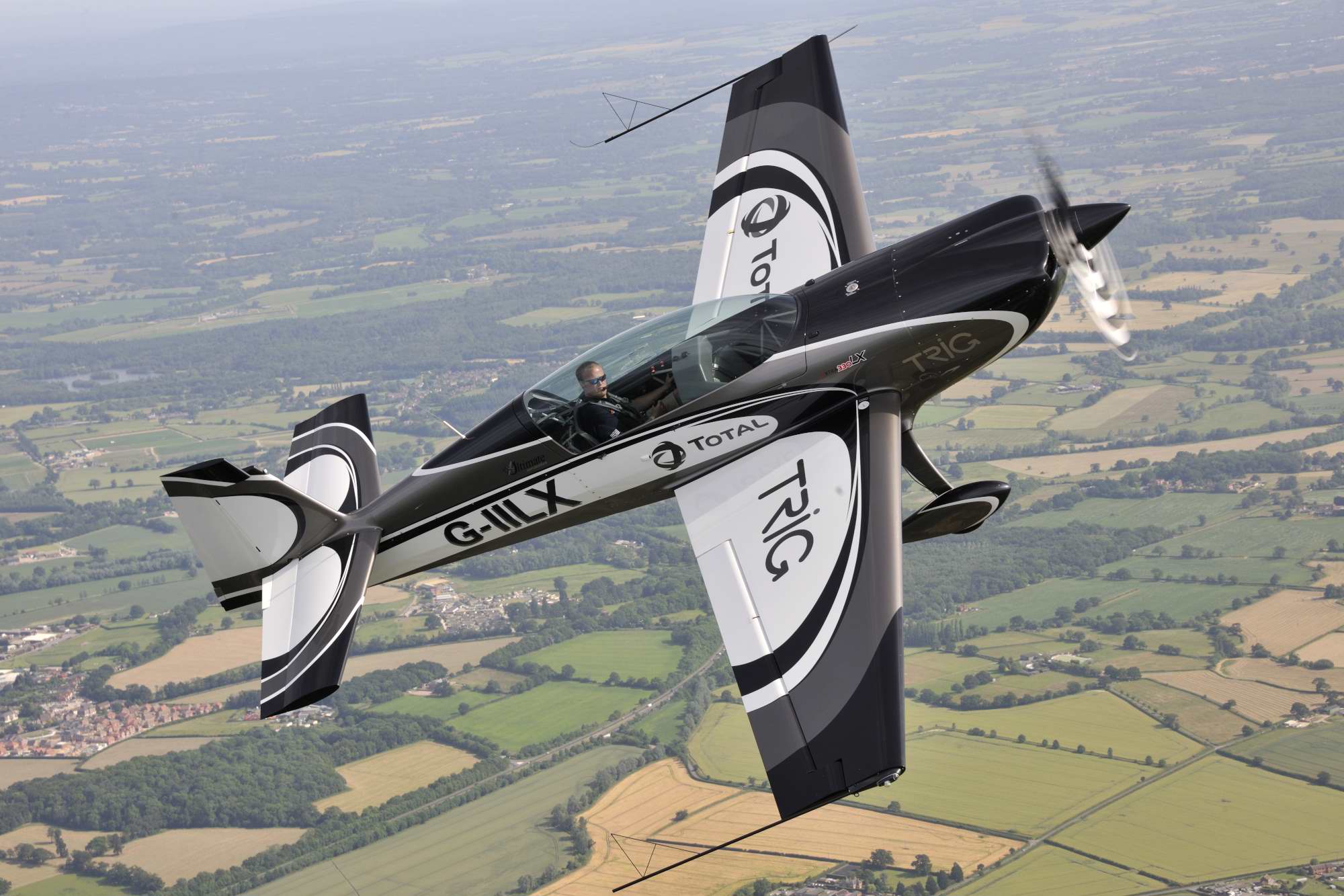 Aerobatic aircraft banking over countryside near Sibson and Peterborough