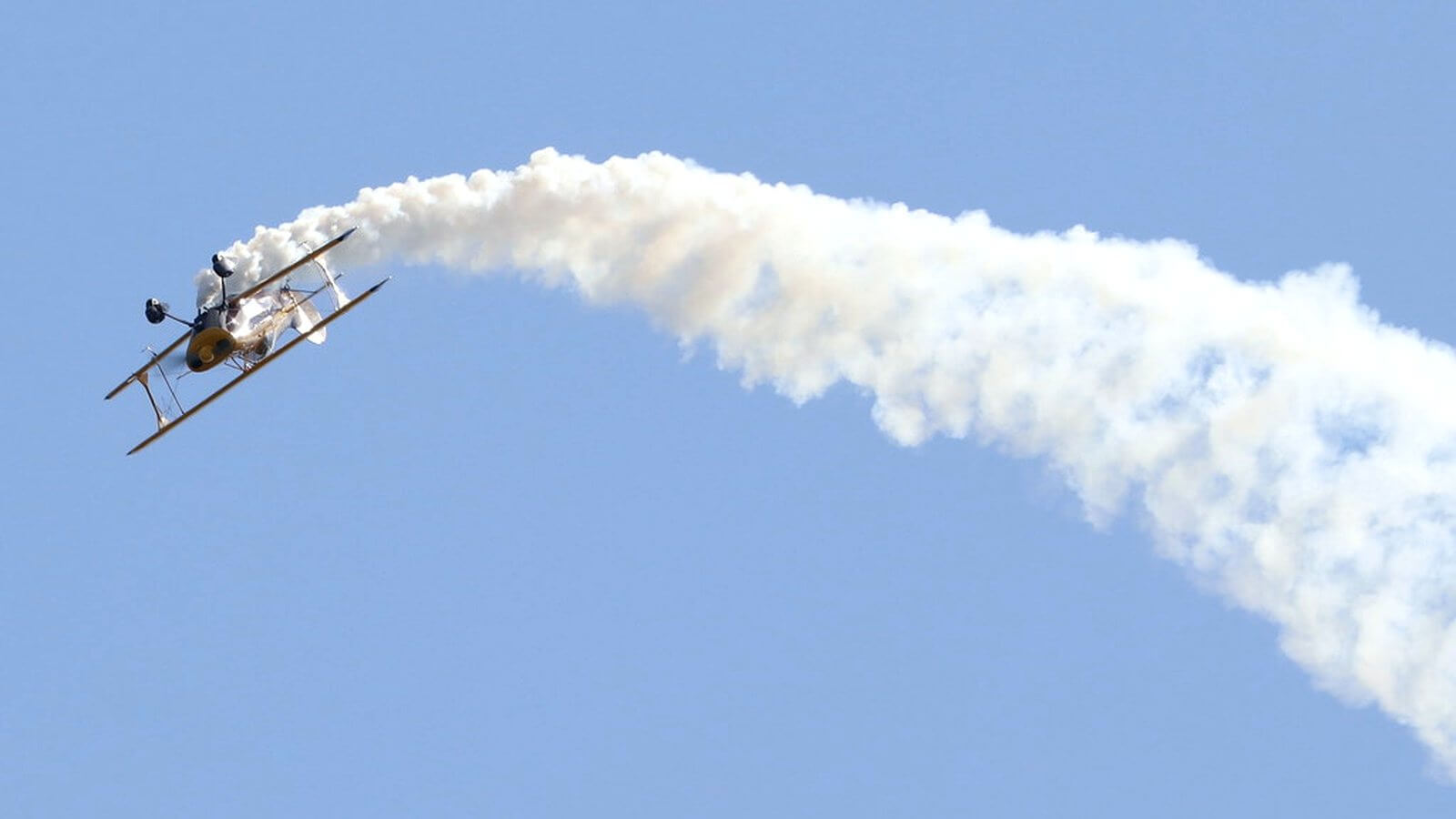 Aerobatic aircraft banking over the countryside near White Waltham